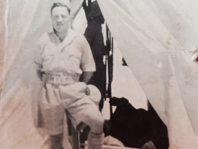 A Māori man in a military uniform standing outside a tent.