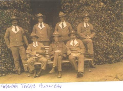 Seven First World War soldiers, three seated and four standing.