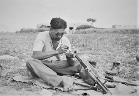 Soldier sitting and cleaning gun